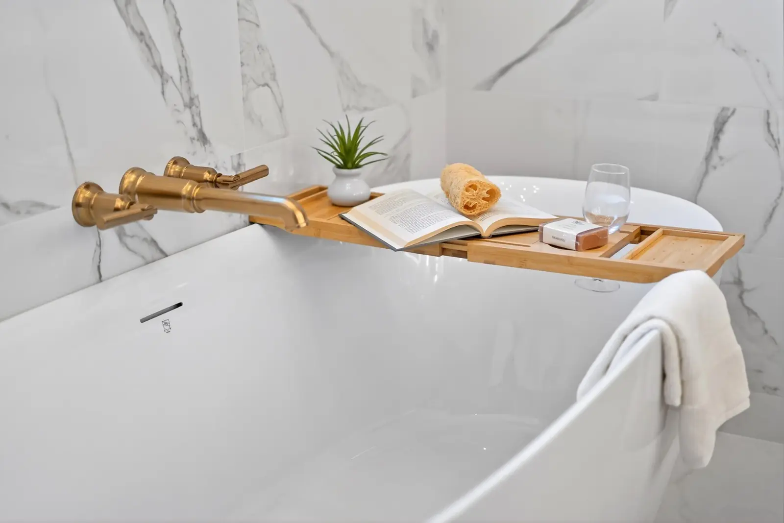 Freestanding tub with marble walls and brass filler