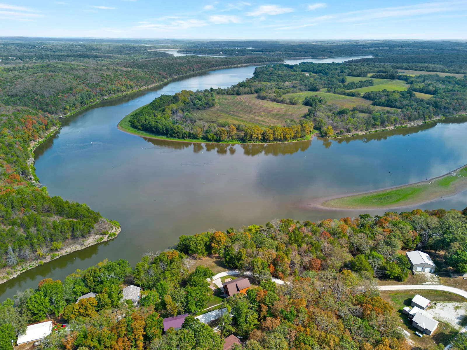 Aerial view of a sweeping bend in a lake with wooded shoreline